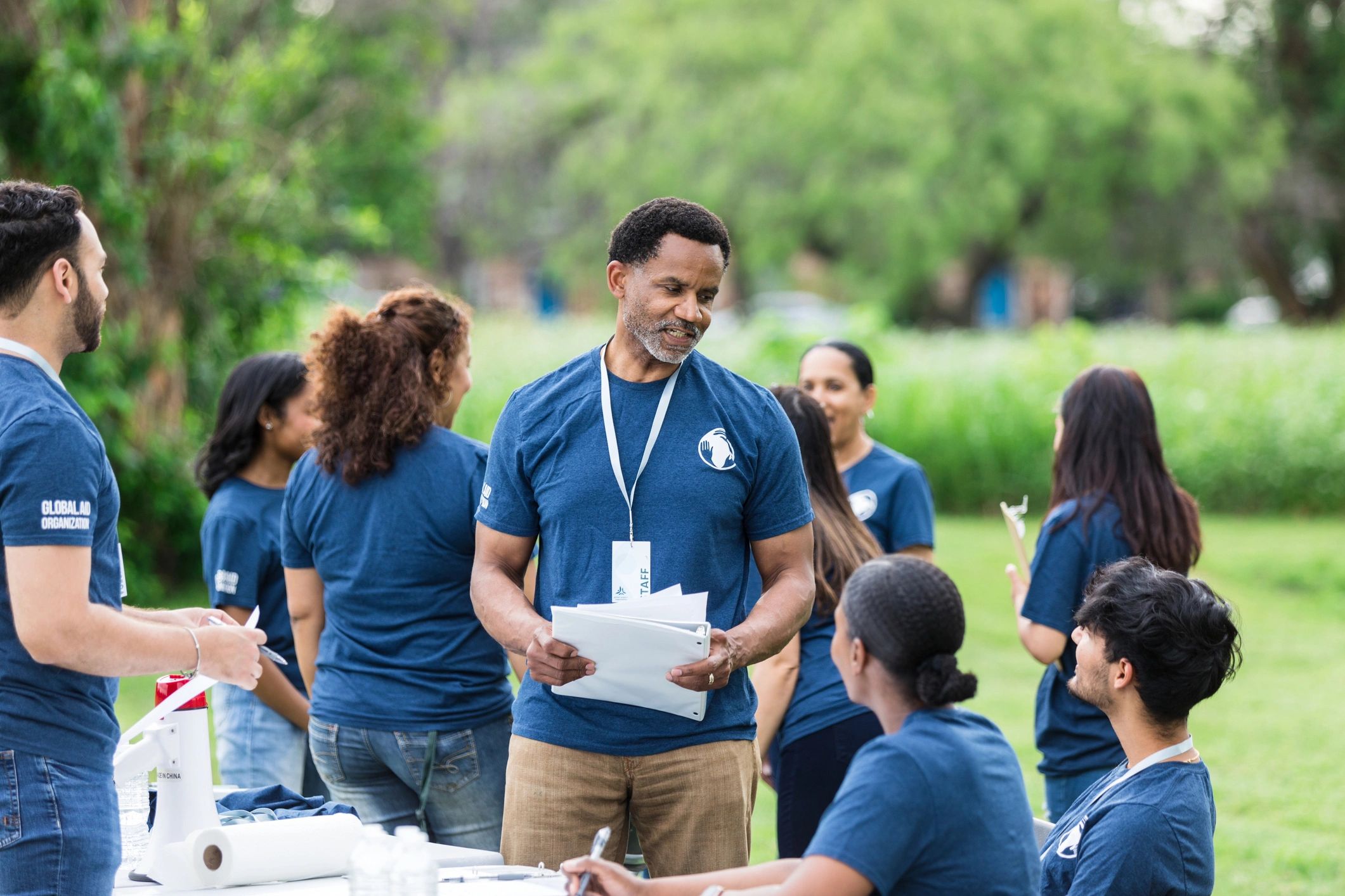 Volunteer leader speaking with a small team during a community event