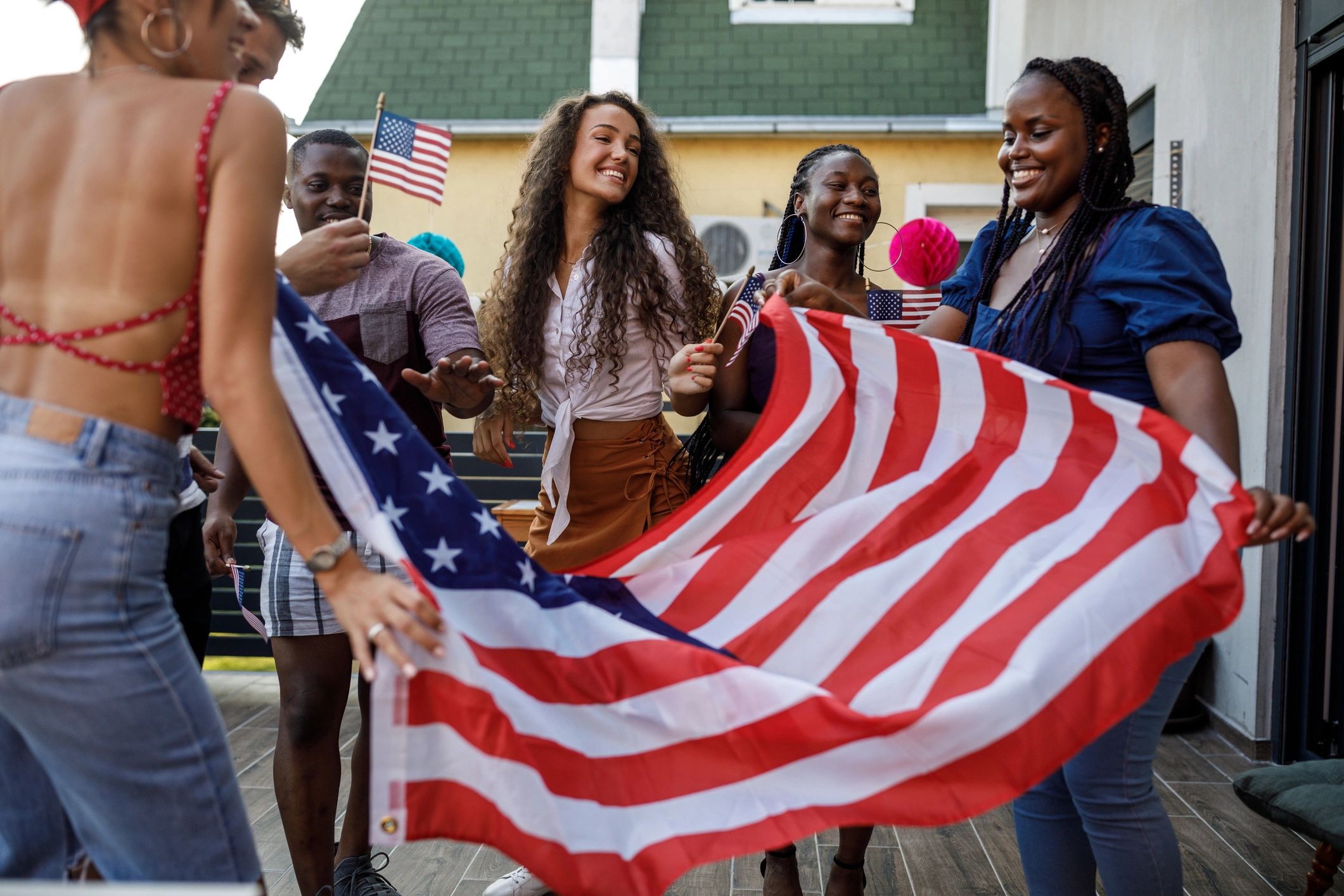 Community group holding a large American flag during a celebration